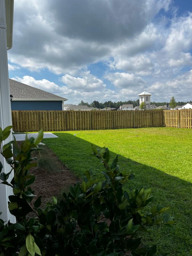 Wood privacy fence across a green backyard