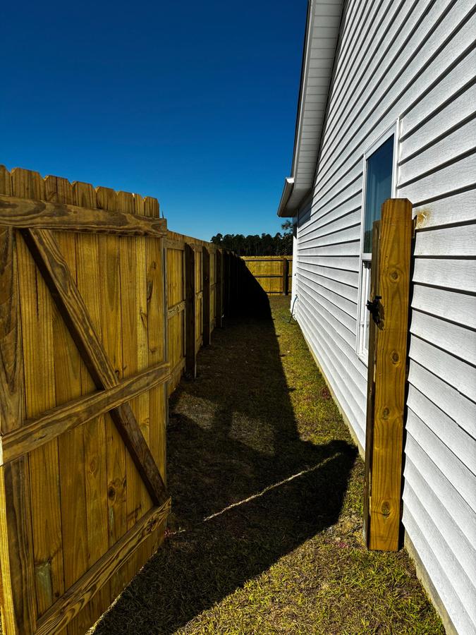 Wood side-yard fence and gate running along a house